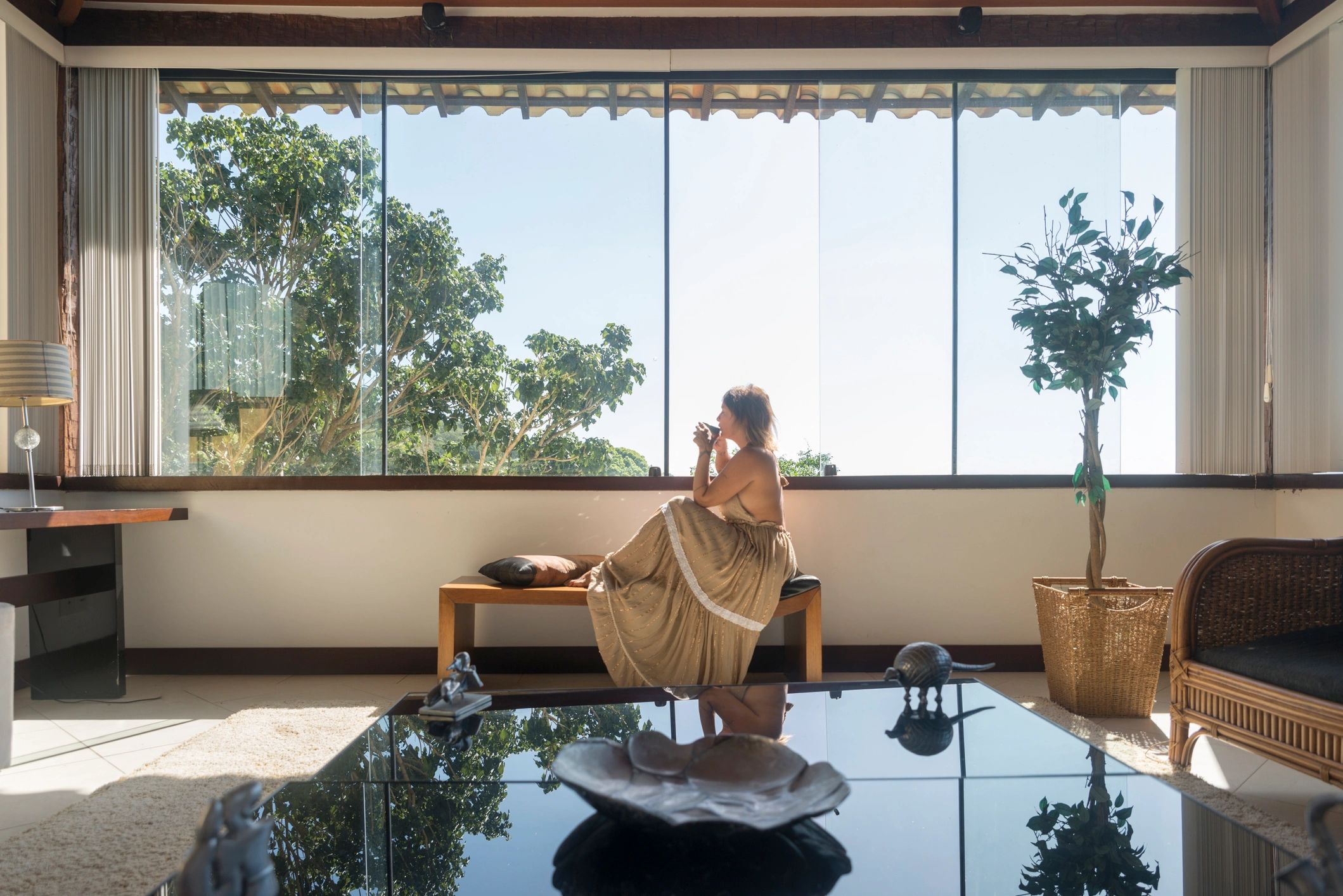 Mature woman holding a warm drink by a window