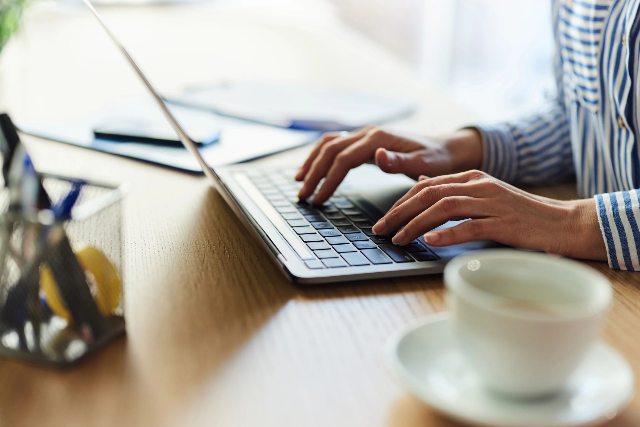 Person learning online on a laptop with a notebook nearby