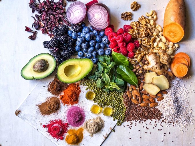 Colorful whole foods and spices arranged on a wooden table